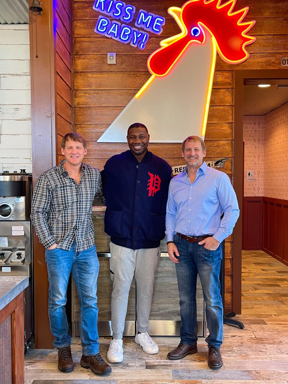 Micheal (left) and Craig Colby (right) stand with partner Ryan Howard (middle).