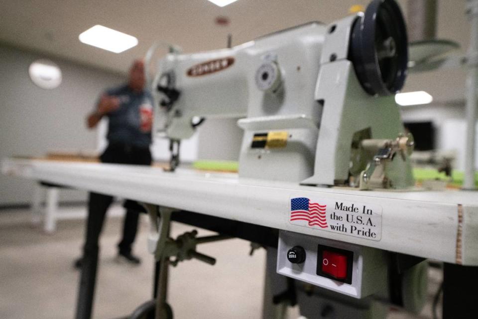 A sewing machine sits in the foreground of a CAVE classroom while Belleville School District 201 Superintendent Brian Mentzer explains how students receive training on cabinet finishing, composites and upholstery for aircraft.
