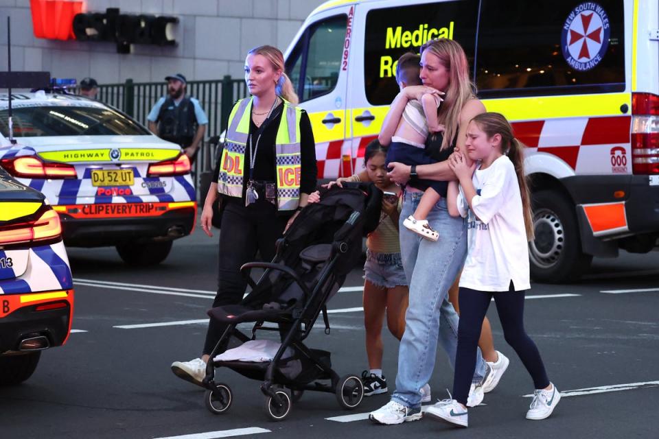 Families walk out of the Westfield Bondi Junction shopping mall after a stabbing incident in Sydney on 13 April 2024 (AFP via Getty Images)