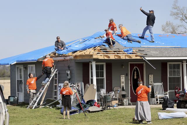 <p>Scott Olson/Getty</p> Volunteers from Samaritan's Purse help a homeowner recover in the aftermath of a tornado on March 28, 2023 in Silver City, Mississippi.