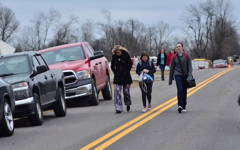 Parents leave the school with their daughter - Credit: AP