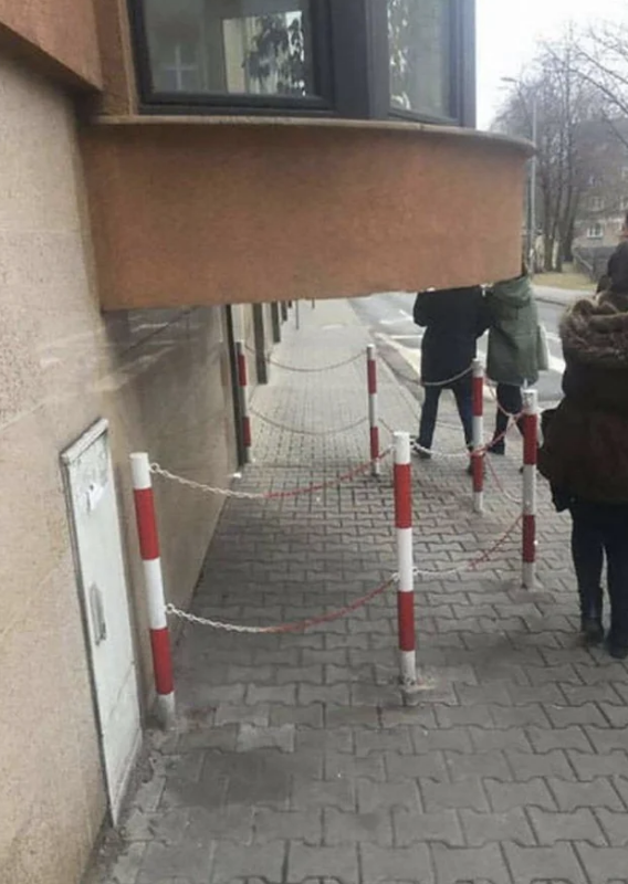 people walking outside have to avoid hitting their heads on the balcony