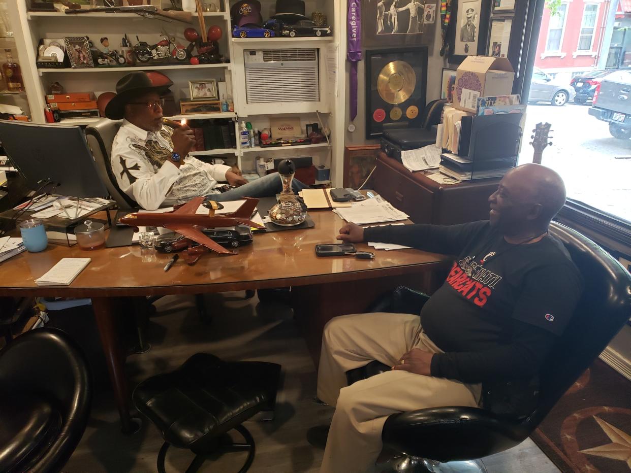 Marvin Butts, owner of Mr. Bubbles Detailing in Pendleton and founder of the Butts Family Foundation, lights a cigar in his office to celebrate with longtime friend Gary Brown, of Forest Park.  Butts and Brown began raising money in January to help pay outstanding fees for more than 300 students at five Cincinnati Public Schools high schools so their diplomas and transcripts would not be withheld.