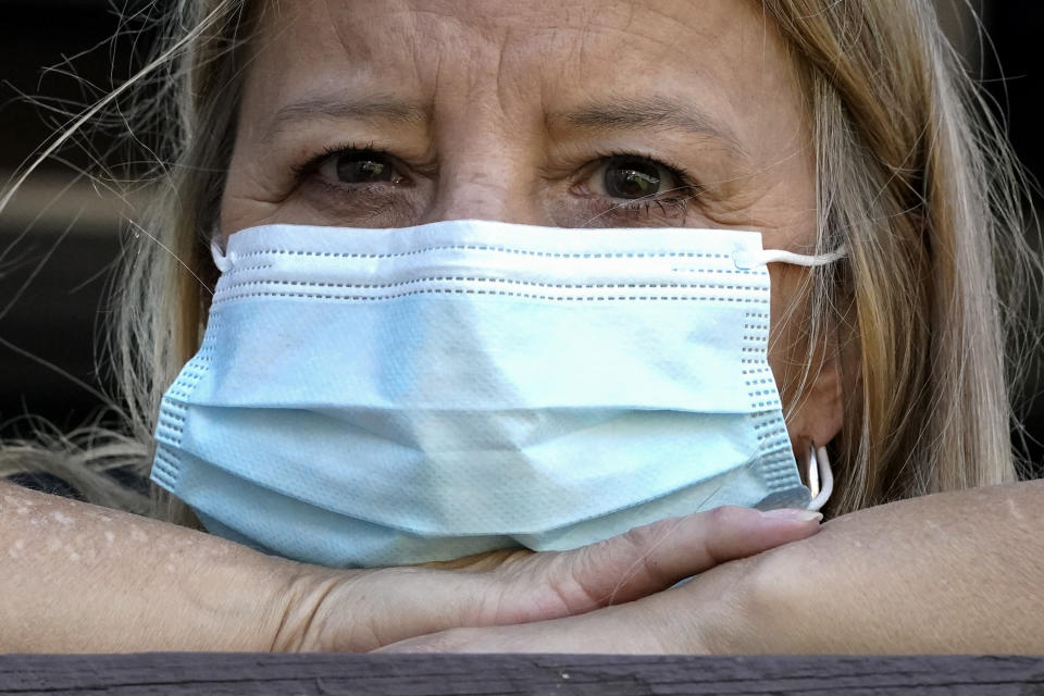 FILE - A woman wears a mask at her home after previously having COVID in Des Plaines, Ill, Monday, Sept. 27, 2021. January can be the worst month for respiratory illnesses and vaccination rates are low. When relatives, friends and co-workers are coming down with coughs, nasal congestion, fatigue and fever, keeping viruses at bay means thorough hand-washing, good ventilation and wearing a mask in crowded areas. (AP Photo/Nam Y. Huh, File)