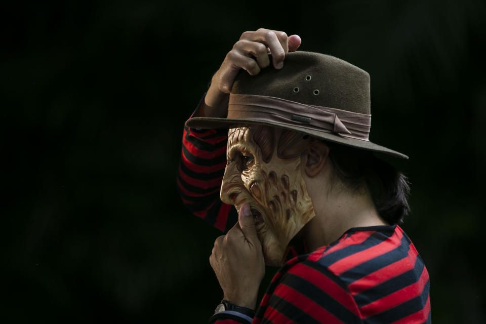 A member of the "Desliga da Justica" street band gets dressed in his costume in Rio de Janeiro, Brazil, Sunday, Feb. 14, 2021. The group's performance was broadcast live on social media for those who were unable to participate in the carnival due to COVID restrictions after the city's government officially suspended Carnival and banned street parades or clandestine parties. (AP Photo/Bruna Prado)