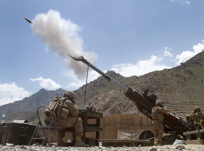 Soldiers fire a 155 mm howitzer at insurgent positions in Afghanistan.