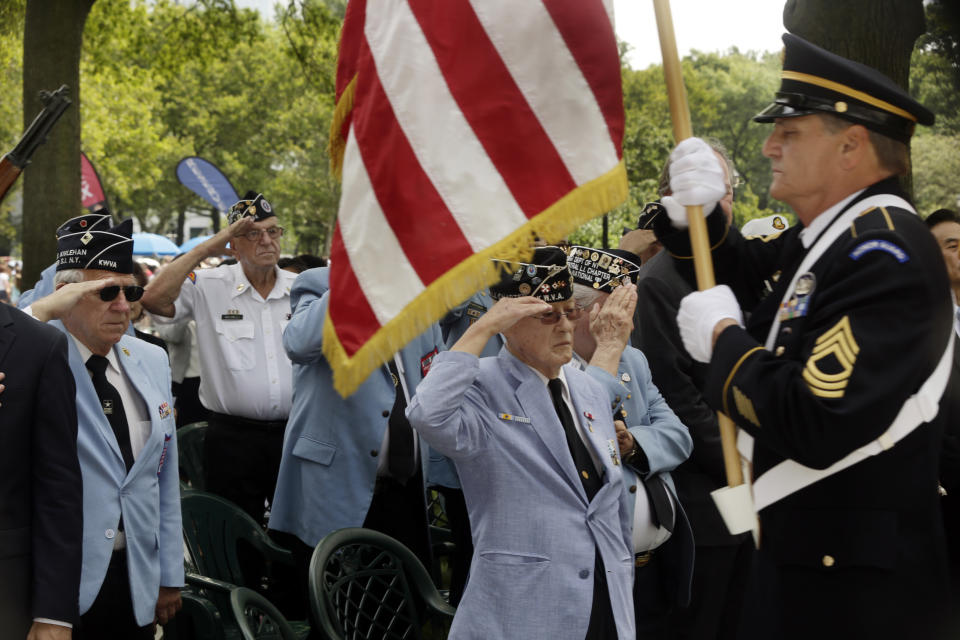 Korean War Veterans salute as a member of an honor guard presents the American flag at the Korean War memorial at Battery Park in New York, Friday, July 27, 2018. Korean War veterans have something extra to celebrate as they mark the 65th anniversary of the armistice that ended combat. (AP Photo/Stephen Groves)