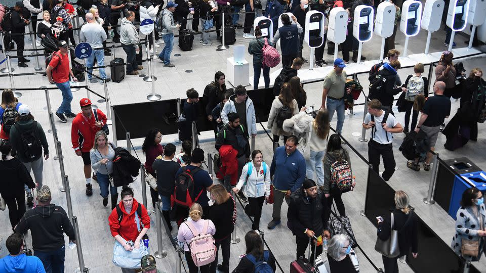 Travelers wait in a TSA security screening line at Orlando International Airport in Florida two days before Christmas Eve in 2022. Traveling on Christmas Day might save you money -- and you're likely to have fewer people with grapple with in the airport and on the flight. - Paul Hennessy/SOPA Images/Shutterstock