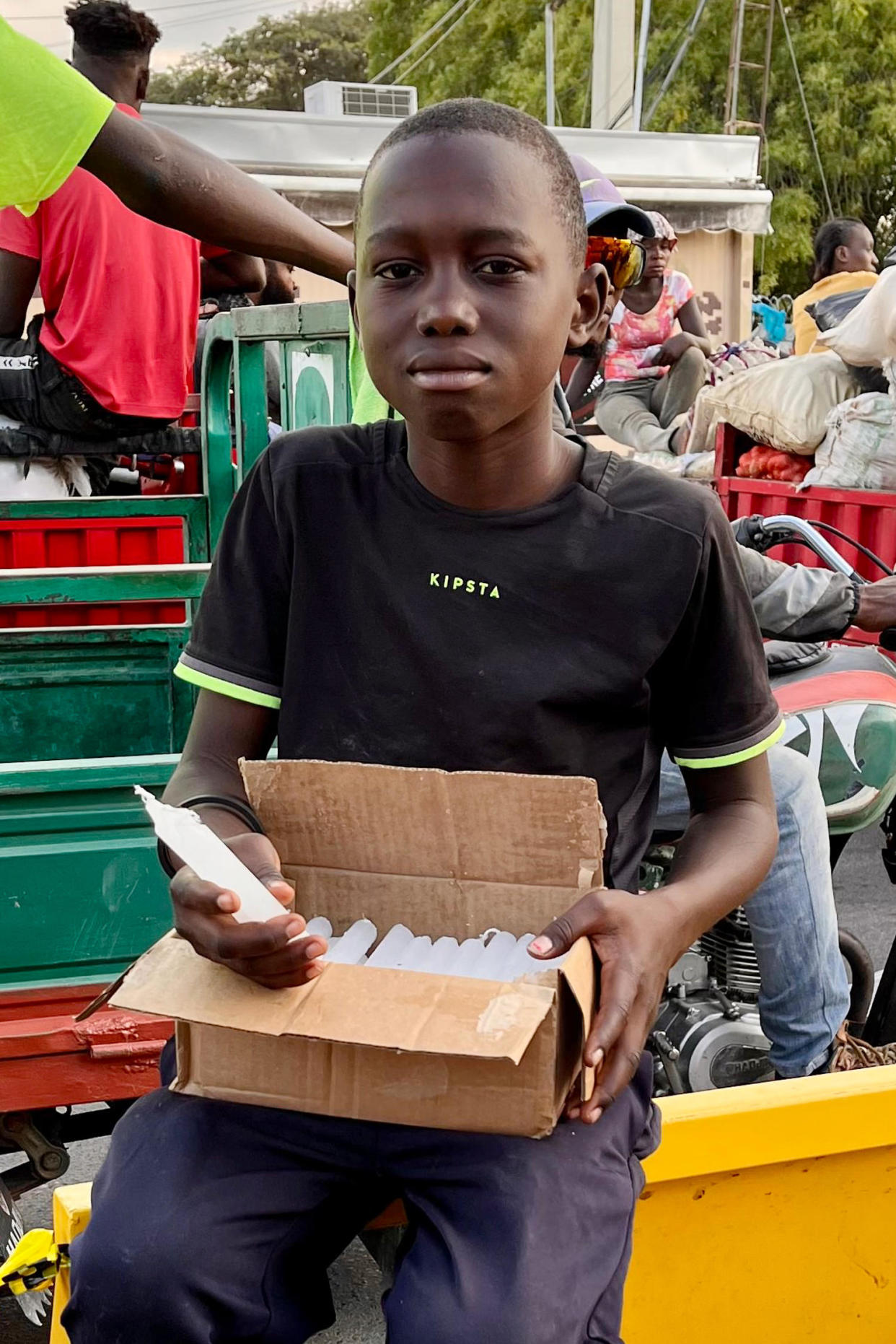 Kelvin Vensy holds a box of candles in the street. ( Erika Angulo)