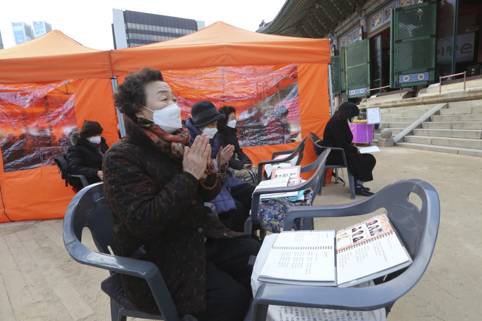 Parents wearing face masks as a precaution against the coronavirus pray during a special service to wish for their children's success in the upcoming college entrance exam on Thursday, Dec. 3, at the Jogye Temple in Seoul, South Korea, Sunday, Nov. 29, 2020. South Korea is shutting down indoor gyms offering intense workout classes and banning year-end parties at hotels in the greater Seoul area to fight the virus. Prime Minister Chung Sye-kyun said Sunday. (AP Photo/Ahn Young-joon)