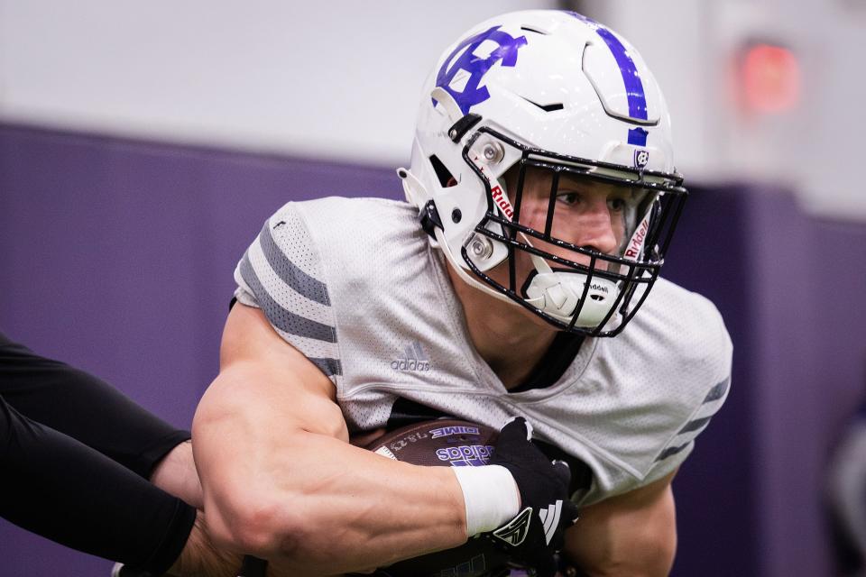 Holy Cross' Jordan Fuller takes a handoff during football spring practice Tuesday.