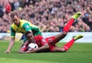 Liverpool midfielder Raheem Sterling (R) grips the ball after being fouled by Norwich City defender Steven Whittaker at Carrow Road in Norwich on April 20, 2014