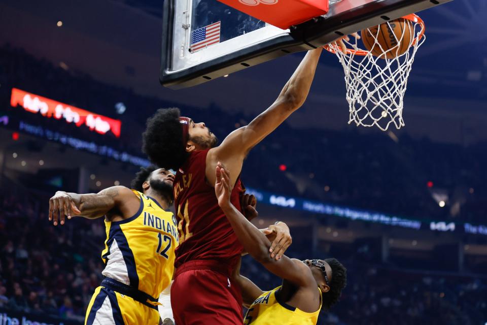 Cavaliers center Jarrett Allen dunks against Pacers forward Oshae Brissett and Jalen Smith during the first half, Sunday, April 2, 2023, in Cleveland.