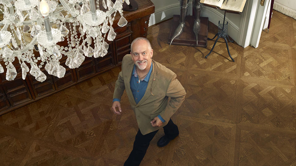 Garriott at home in New York. Behind him are a 17th-century Germanic suit of armor and other pieces from his collection of ancient artifacts. - Credit: Chris Buck