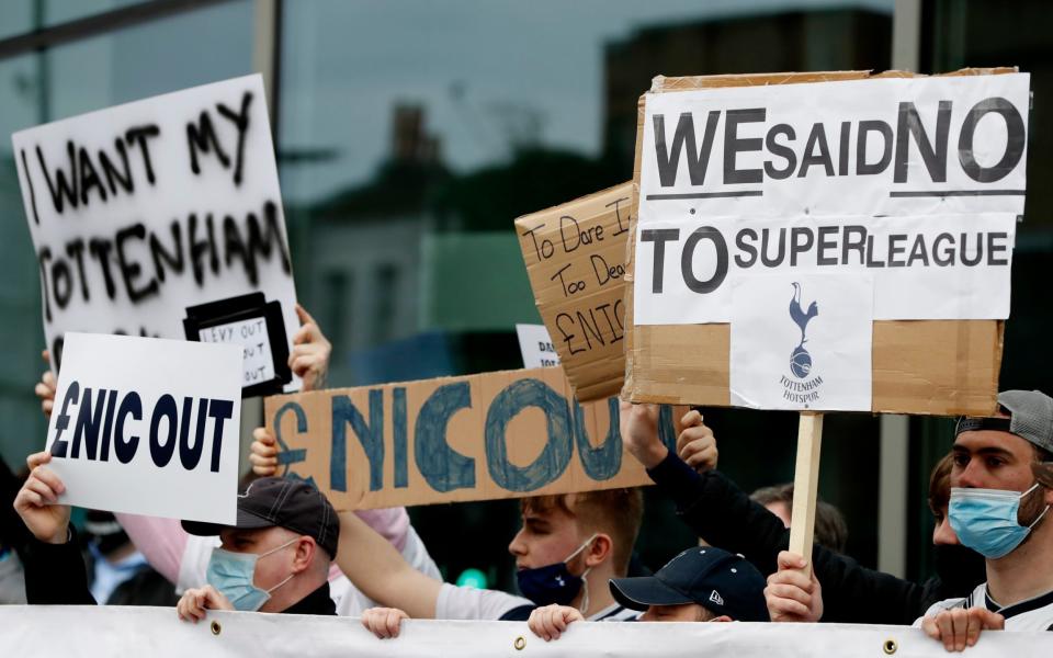 Tottenham fans hold banners protesting against the board outside the stadium - Reuters