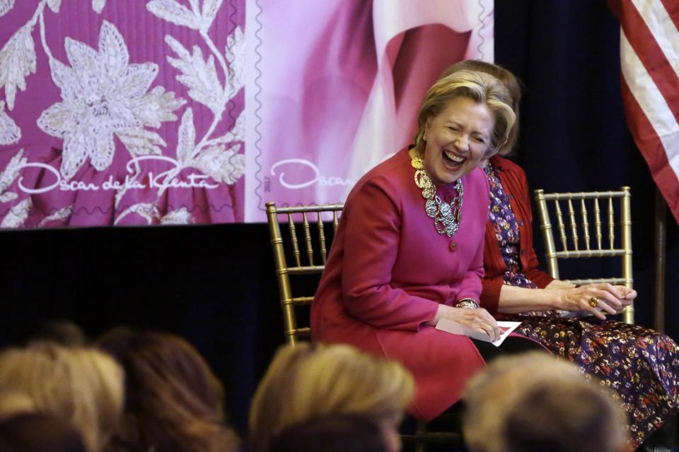 Hillary Clinton reacts to a comment by Michael Bloomberg during ceremonies in Grand Central Terminal where Oscar de la Renta stamps were unveiled, in New York, Thursday, Feb. 16, 2017. Clinton has praised Oscar de la Renta as an inspiration to striving immigrants like himself at an event honoring the late fashion designer with a series of commemorative stamps. (AP Photo/Richard Drew)