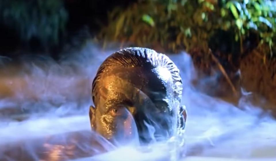 Willard emerging from the foggy river with mud on his face in "Apocalypse Now"