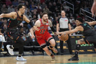 Chicago Bulls forward Onuralp Bitim (17) has the ball knocked away by Washington Wizards guard Johnny Davis, right, during the first half of an NBA basketball game Friday, April 12, 2024, in Washington. Wizards forward Patrick Baldwin Jr., left, looks on. (AP Photo/Mark Schiefelbein)