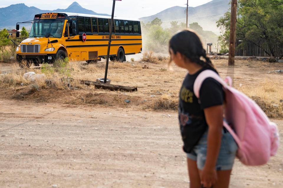 Xochitli Rivera, 11, watches the school bus take students to the local high school while she waits for her bus to Mesa Middle School on Thursday, July 28, 2022. The bus is supposed to arrive at 7:45 am, but Rivera's mother, Michelle, has been taking her to school so she does not miss first period.