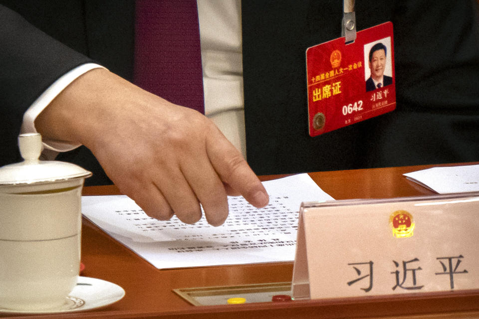 Chinese President Xi Jinping reaches to push a button to vote on a measure during a session of China's National People's Congress (NPC) at the Great Hall of the People in Beijing, Friday, March 10, 2023. Chinese leader Xi Jinping was awarded a third five-year term as president Friday, putting him on track to stay in power for life at a time of severe economic challenges and rising tensions with the U.S. and others. (AP Photo/Mark Schiefelbein)