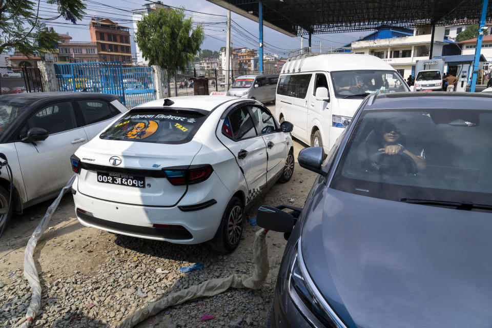 A man sits waits in his electric car while recharging at a charging station in Kathmandu, Nepal, Tuesday, May 14, 2024. Nearly all of the electricity produced in Nepal is clean energy, most of it generated by river-fed hydro-electricity. Thanks to that abundant source of power, the country is quickly expanding charging networks and imports of EVs have doubled in each of the past two years, according to customs data. (AP Photo/Niranjan Shrestha)