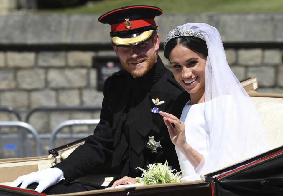 FILE - Britain's Prince Harry, Duke of Sussex, and his wife Meghan Markle, Duchess of Sussex, wave from the Ascot Landau Carriage during their carriage procession on Castle Hill outside Windsor Castle in Windsor, England, May 19, 2018, after their wedding ceremony. The pomp, the glamour, the conflicts, the characters — when it comes to the United Kingdom’s royal family, the Americans can’t seem to get enough. (Paul Ellis/Pool Photo via AP, File)