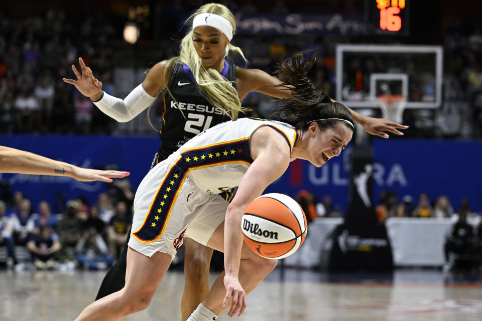 Connecticut Sun guard DiJonai Carrington (21) fouls Indiana Fever guard Caitlin Clark (22) during the third quarter of a WNBA basketball game, Tuesday, May 14, 2024, in Uncasville, Conn. (AP Photo/Jessica Hill)