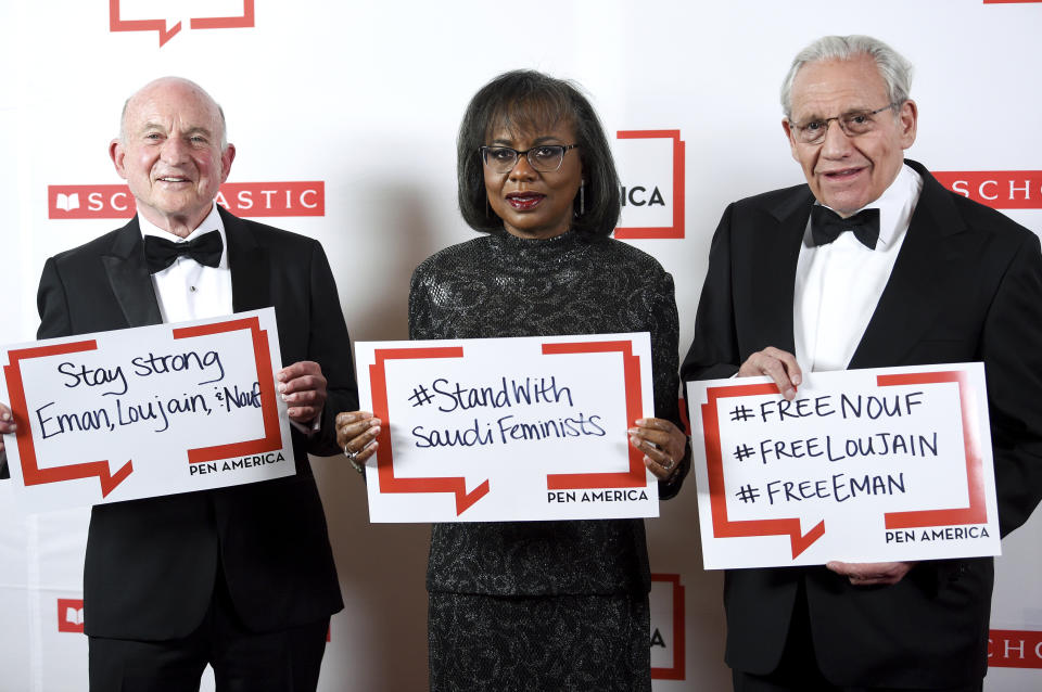 PEN publisher award recipient Richard Robinson, left, PEN courage award recipient Anita Hill and PEN literary service award recipient Bob Woodward pose together holding signs in support of jailed Saudi women's rights activists Nouf Abdulaziz, Loujain Al-Hathloul and Eman Al-Nafjan at the 2019 PEN America Literary Gala at the American Museum of Natural History on Tuesday, May 21, 2019, in New York. (Photo by Evan Agostini/Invision/AP)