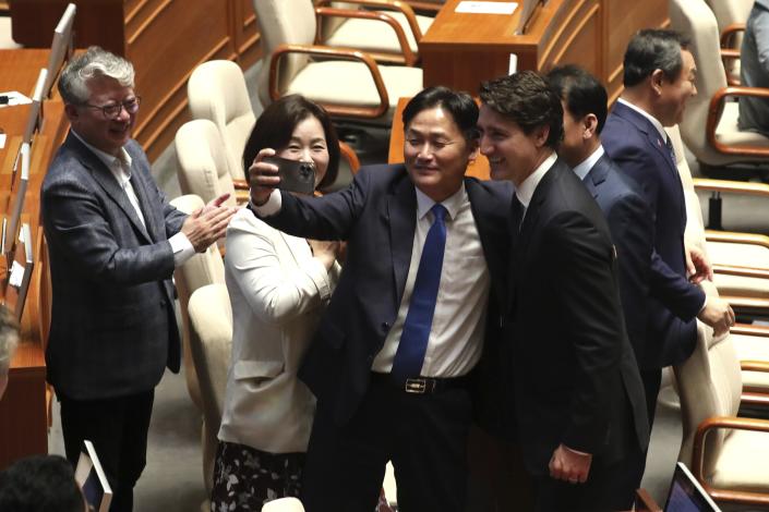 Canadian Prime Minister Justin Trudeau, poses for a selfie with South Korean lawmakers after delivering his speech at the National Assembly in Seoul, South Korea, Wednesday, May 17, 2023. (Korea Pool/Yonhap via AP)
