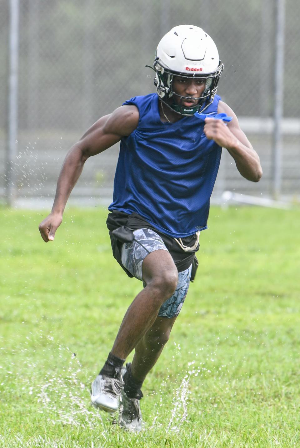 Heritage High football players practice in a driving rain on Aug. 1, 2023.