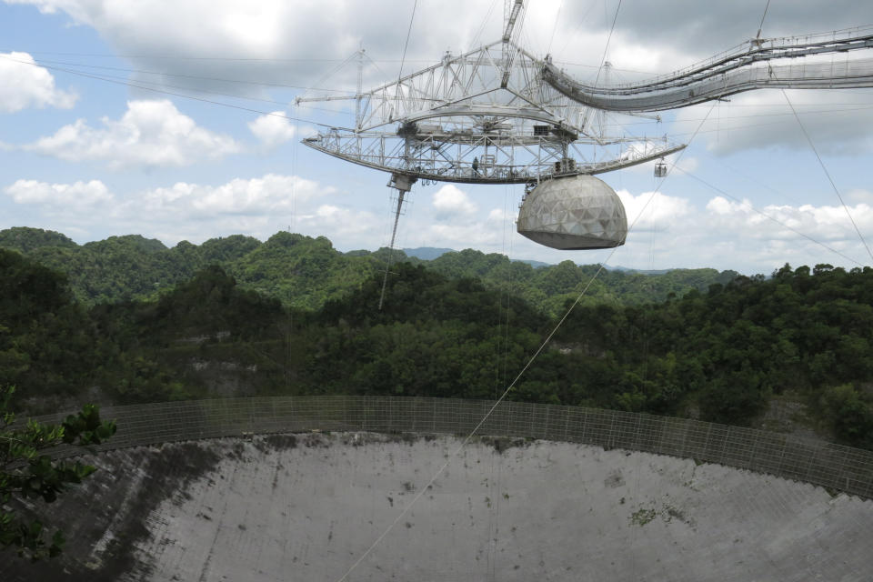 FILE - This July 13, 2016 file photo shows one of the largest single-dish radio telescopes at the Arecibo Observatory in Arecibo, Puerto Rico. Giant, aging cables that support the radio telescopes are slowly unraveling in this U.S. territory, threatening scientific projects that researchers say can’t be done elsewhere on the planet. (AP Photo/Danica Coto, File)