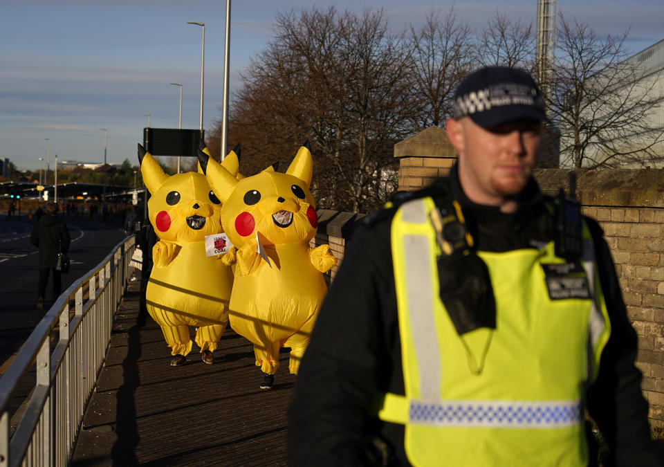 Activists dressed as the Pokemon character Pikachu follow a police officer as they protest against Japan's support of the coal industry near the COP26 U.N. Climate Summit in Glasgow, Scotland, Thursday, Nov. 4, 2021. The U.N. climate summit in Glasgow gathers leaders from around the world, in Scotland's biggest city, to lay out their vision for addressing the common challenge of global warming. (AP Photo/Alberto Pezzali)