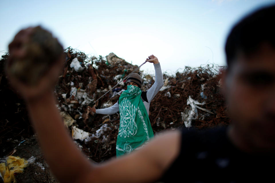 <p>A Palestinian protester, nicknamed Abu Akram, wearing a Hamas flag, holds a sling as he poses for a photograph at the scene of clashes with Israeli troops near the border with Israel, east of Gaza City, Jan. 19, 2018. “We are here to protest against the Israeli blockade on Gaza which led to the deterioration of the economic situation, and to show our commitment to defend Jerusalem. We hope that the blockade on Gaza will be lifted soon,” said Abu Akram. (Photo: Mohammed Salem/Reuters) </p>