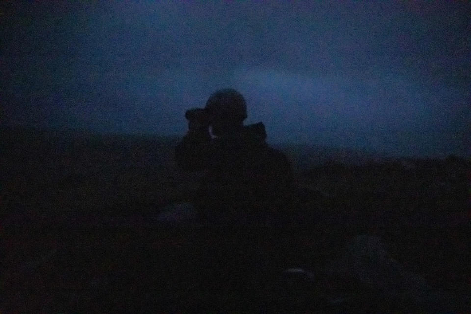 Un militar ucraniano de la 95.a Brigada de Asalto Aéreo usa lentes de visión térmica mientras está de guardia en un sistema de trincheras a lo largo de la línea del frente en la región de Donetsk cerca de Izium, Ucrania, el 26 de mayo de 2022. (Finbarr O'Reilly/The New York Times)
