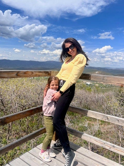 Nour Kasm, shown with one of her three children, and her husband have purchased shares in three vacation homes through Pacaso. She is shown outside their Park City, Utah home.