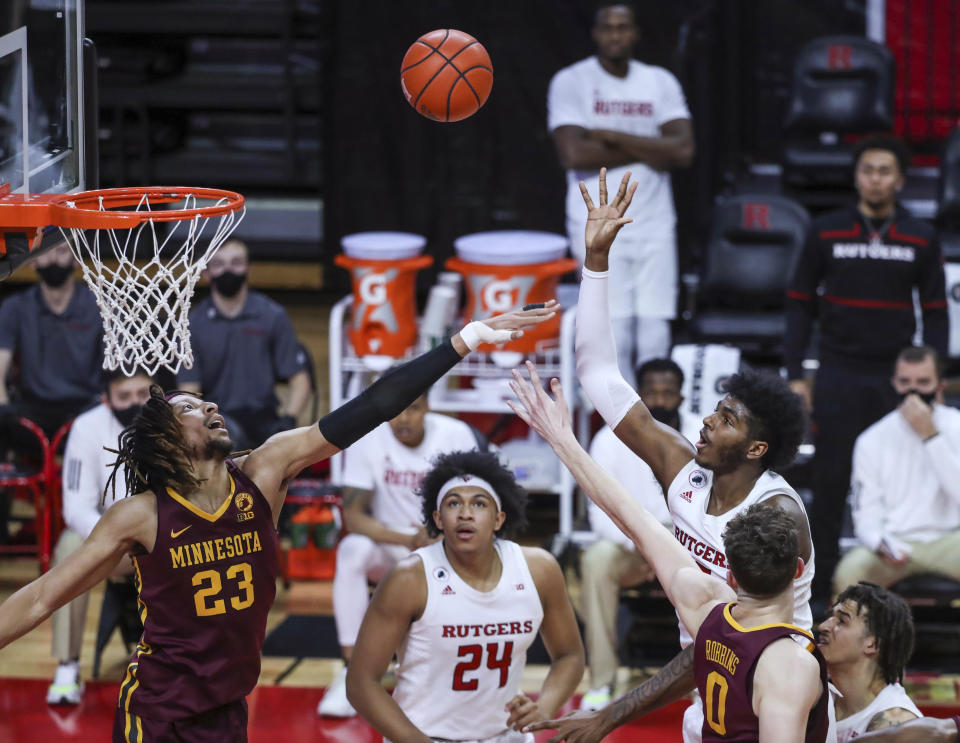 Rutgers center Myles Johnson (15) shoots as Minnesota forward Brandon Johnson (23) and center Liam Robbins (0) defend during the second half of an NCAA college basketball game Thursday, Feb. 4, 2021, in Piscataway, N.J. (Andrew Mills/NJ Advance Media via AP)