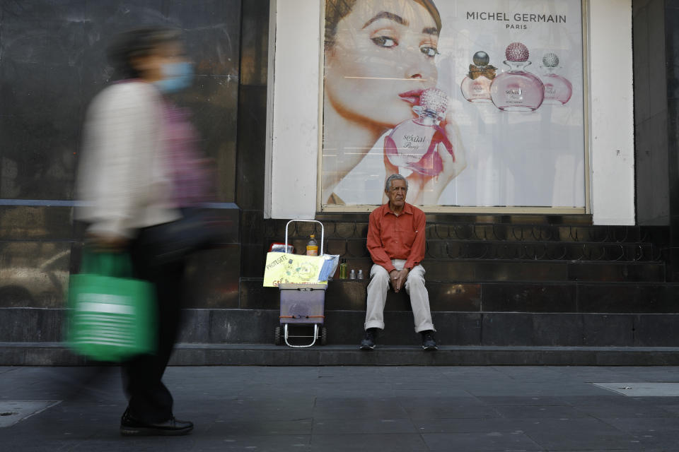 Tomas Gonzalez, 80, markets face masks and antibacterial gel to pedestrians in Mexico City, Monday, March 23, 2020. Gonzalez and his wife had been hawking sandwiches, but switched to selling coronavirus-related products last week. "At 80-years-old, no one will give me work," said the former sales trainer.(AP Photo/Rebecca Blackwell)