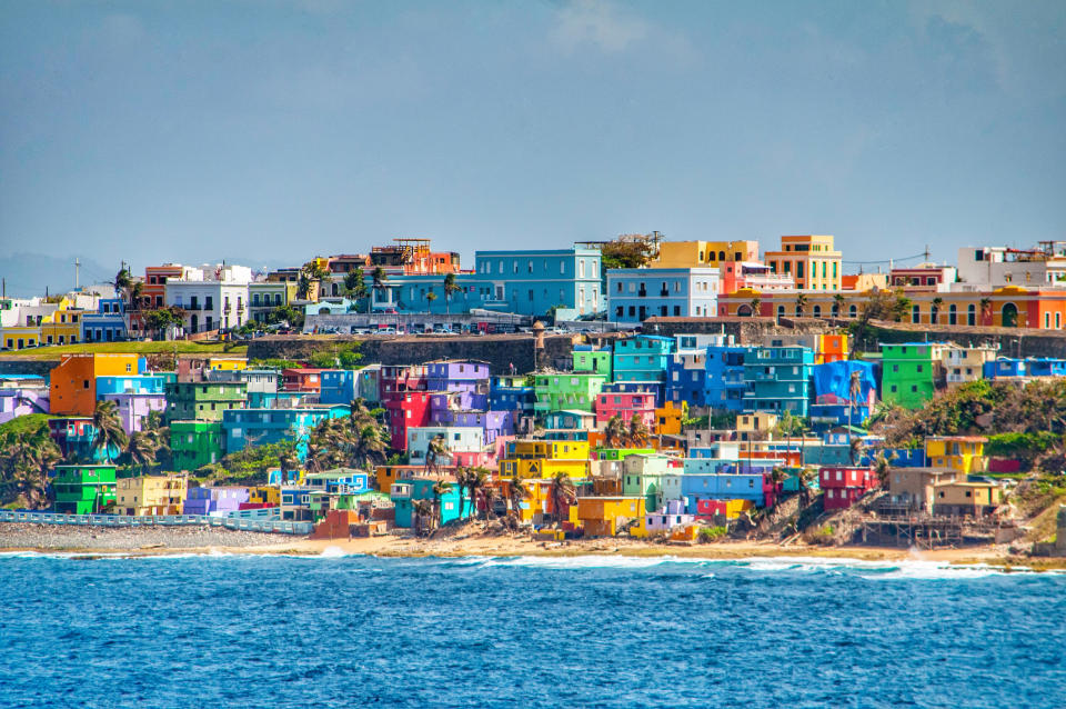 Bright colorful houses line the hills overlooking the beach in San Juan, Puerto Rico.