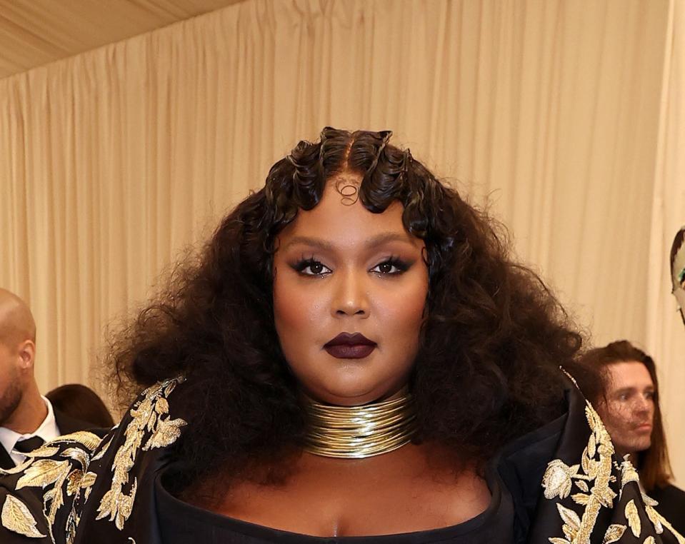 Lizzo wearing a gold choker, dark lipstick, and a '20s-inspired hairdo