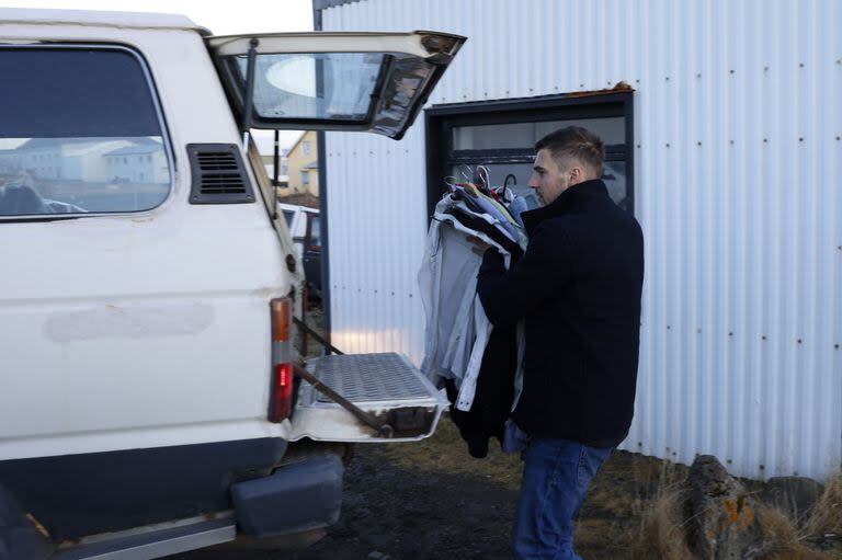 Un residente de la ciudad de Grindavik, Islandia, saca algunas de sus pertenencias de su casa el lunes 13 de noviembre de 2023 