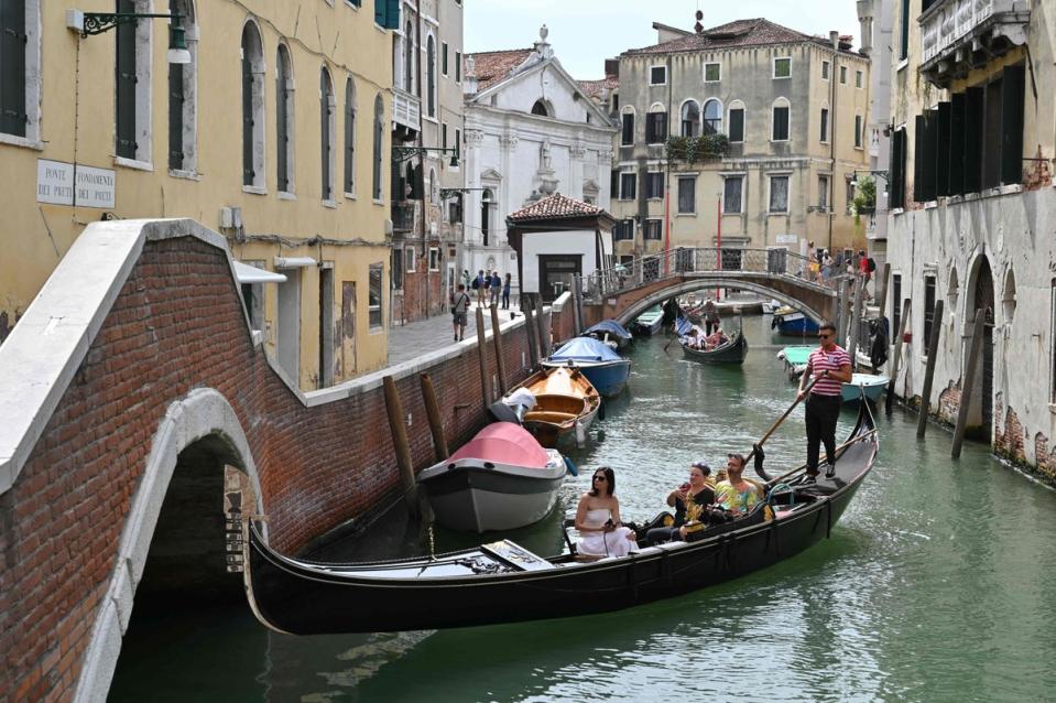 Tourists on a gondola in Venice  (AFP via Getty Images)
