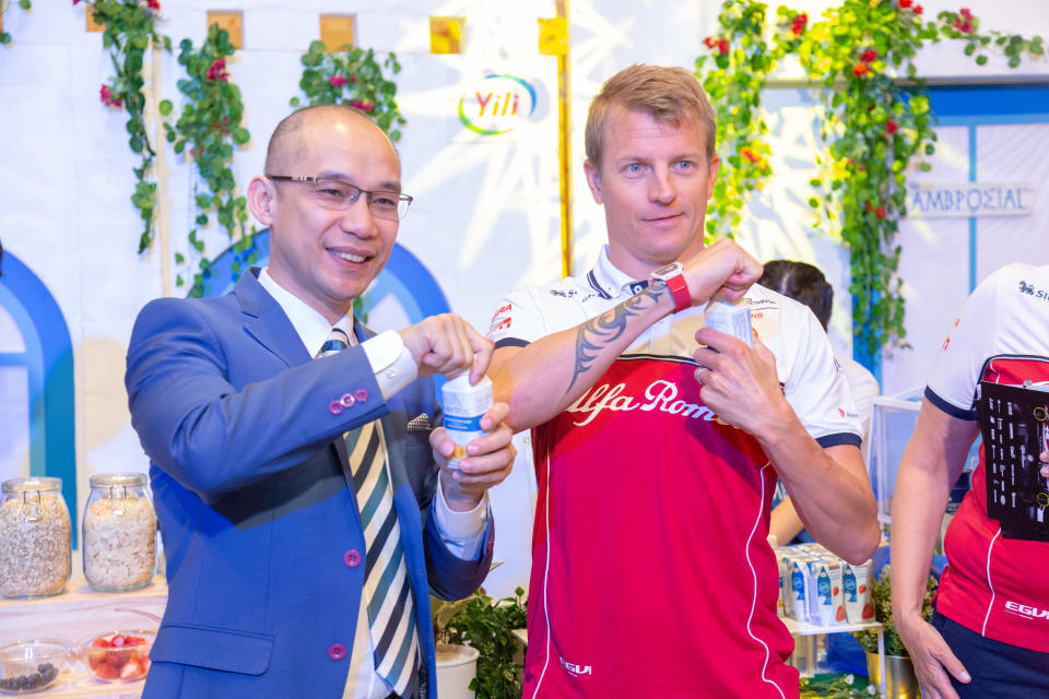 Alfa Romeo Racing driver Kimi Raikkonen (right) at the launch event of Ambrosial yoghurt at Marina Bay Sands, together with Leslie Huang, Yili Group's general manager of international business. (PHOTO: Ricky Ee/Ambrosial)