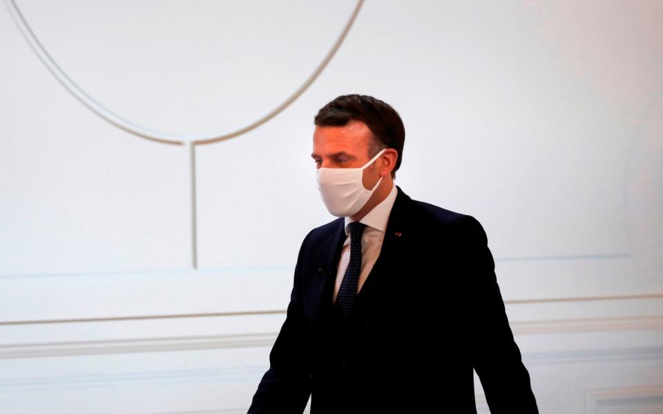 French President Emmanuel Macron, wearing a face mask, arrives to attend a video conference at the Elysee Palace in Paris on January 26, - Francois Mori/AFP