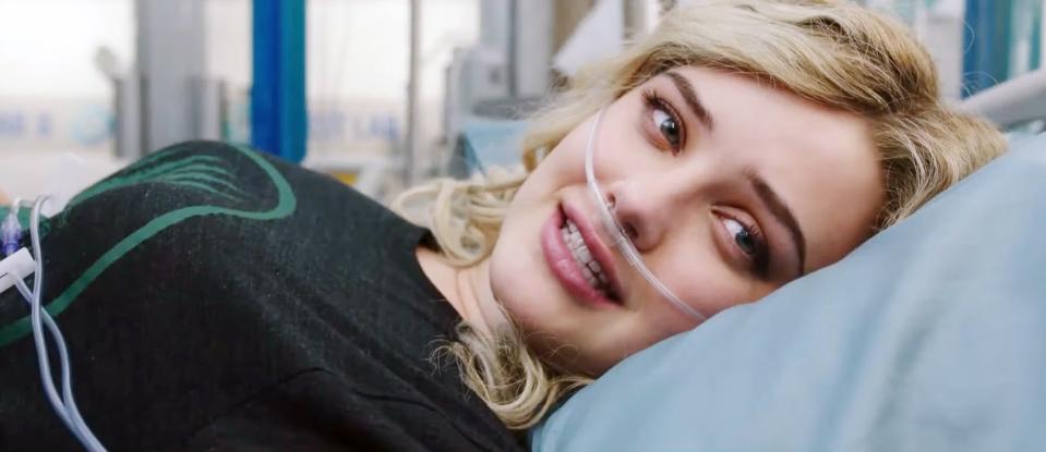 Katherine Langford lies down in a hospital bed