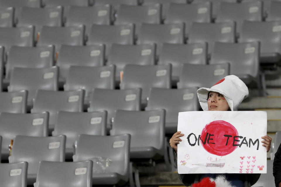 FILE - In this Oct. 20, 2019, file photo, a Japan fan reacts after the Rugby World Cup quarterfinal loss to South Africa at Tokyo Stadium in Tokyo, Japan. The start of the Japanese Top League season will be pushed back until next month after 62 players and staff from six teams tested positive for the coronavirus, the Japan Rugby Football Union said Thursday, Jan. 14, 2021. (AP Photo/Eugene Hoshiko, File)