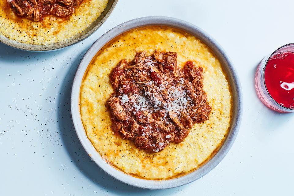 Shredded slow cooker chicken in tomato sauce over creamy polenta is a very good thing to come home to on a chilly weeknight.