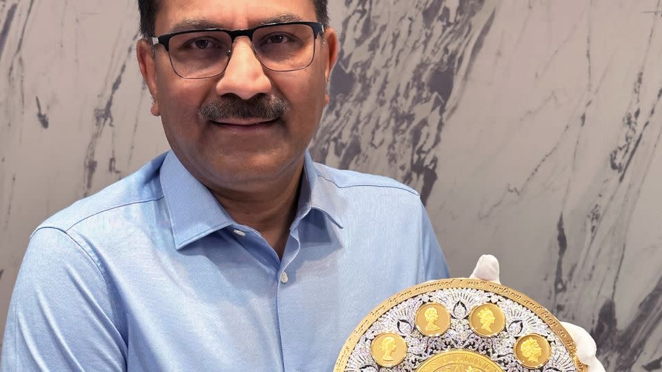 Businessman Sanjiv Mehta, who acquired the rights to the East India Company in 2005, poses with the diamond-encrusted coin. - East India Company