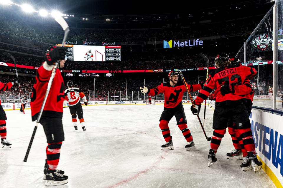 New Jersey Devils players celebrate after Tyler Toffoli, front right, scored against the Philadelphia Flyers in the first period of an NHL Stadium Series hockey game in East Rutherford, N.J., Saturday, Feb. 17, 2024. (AP Photo/Peter K. Afriyie)