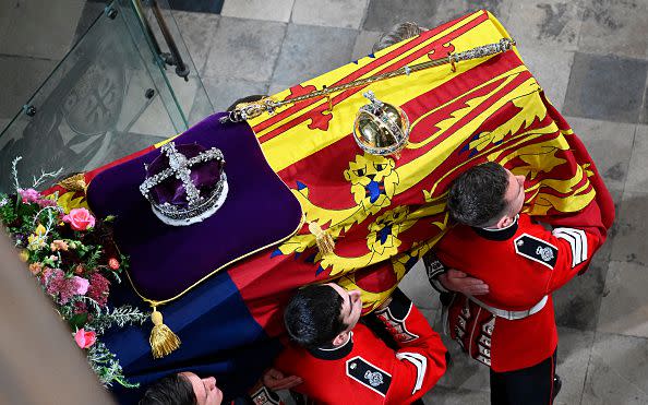 LONDON, ENGLAND - SEPTEMBER 19: The coffin of Queen Elizabeth II with the Imperial State Crown resting on top is carried by the Bearer Party into Westminster Abbey during the State Funeral of Queen Elizabeth II on September 19, 2022 in London, England. Elizabeth Alexandra Mary Windsor was born in Bruton Street, Mayfair, London on 21 April 1926. She married Prince Philip in 1947 and ascended the throne of the United Kingdom and Commonwealth on 6 February 1952 after the death of her Father, King George VI. Queen Elizabeth II died at Balmoral Castle in Scotland on September 8, 2022, and is succeeded by her eldest son, King Charles III.  (Photo by Gareth Cattermole/Getty Images)