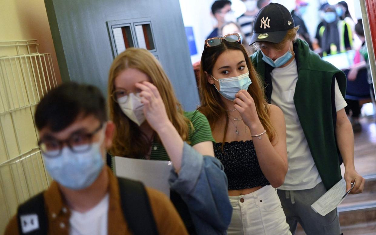 Students wait in a queue to receive a dose of the Pfizer/BioNTech Covid-19 vaccine at a vaccination centre at the Hunter Street Health Centre in London - AFP